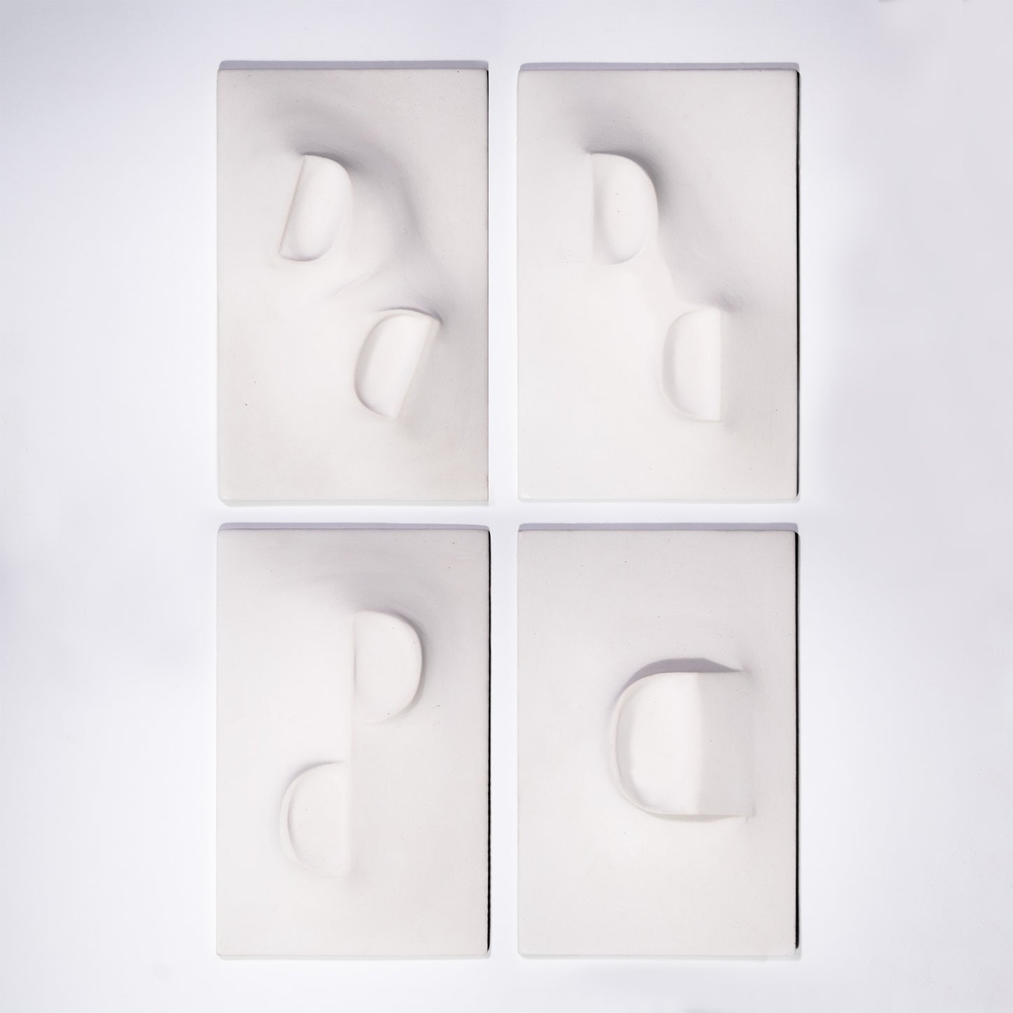 Dancing Balconies, four tiles presented as a relief artwork made from plaster and photographed against a white background