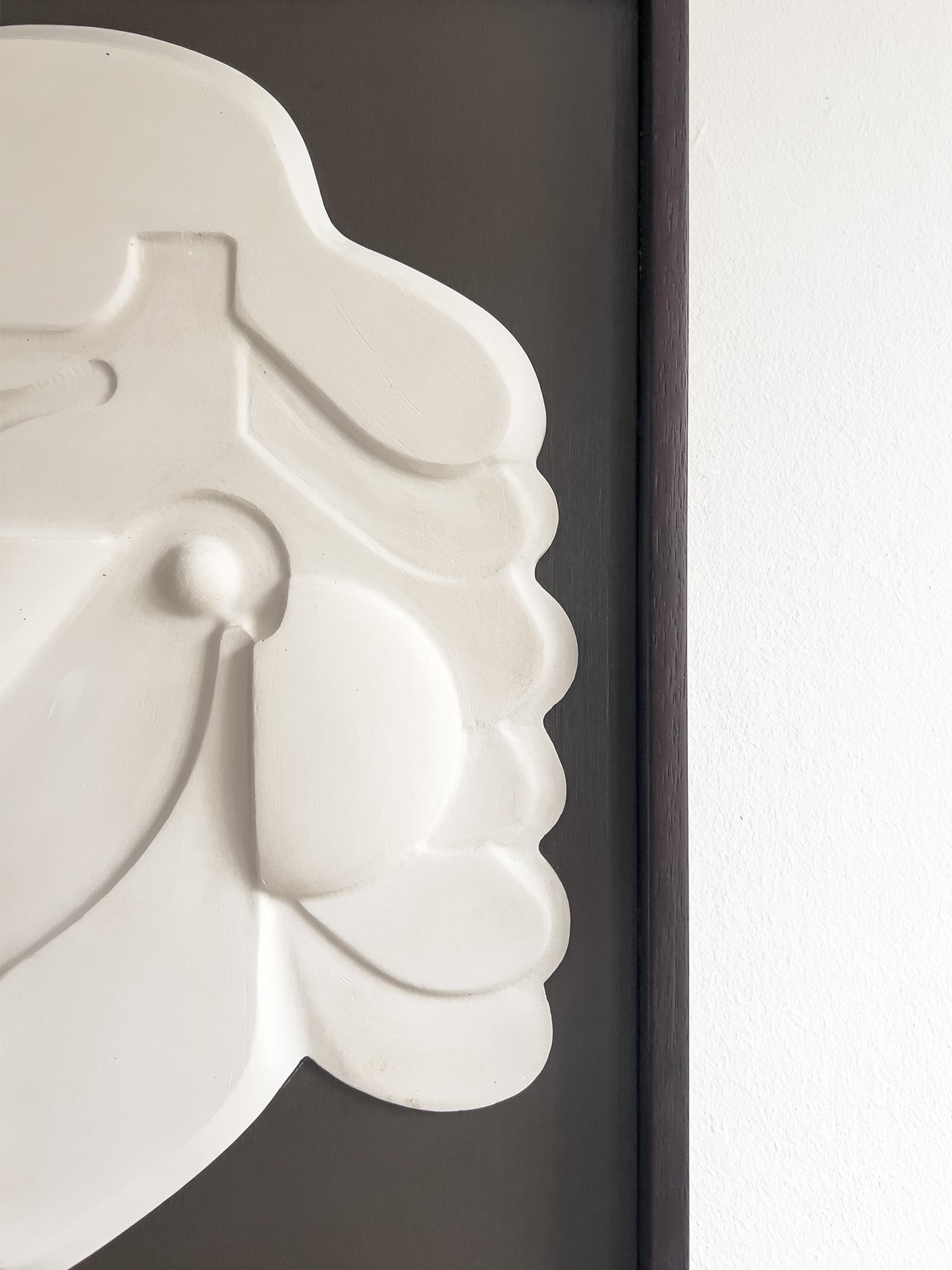 Mask 1, a relief wall sculpture artwork photographed up close. The relief is framed in mahogany stain and brown backboard