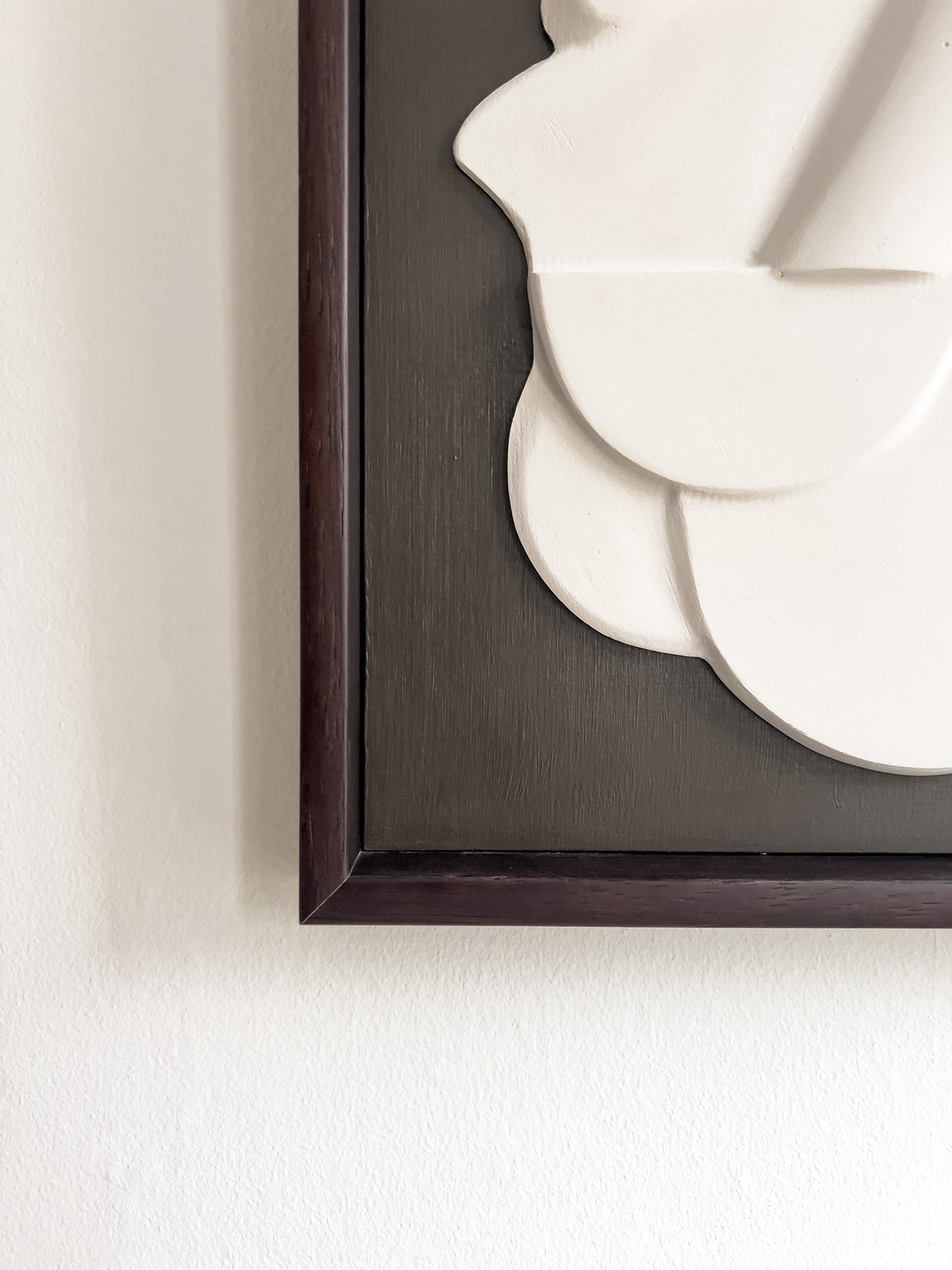 Mask 1, a relief wall sculpture artwork photographed up close. The relief is framed in mahogany stain and brown backboard