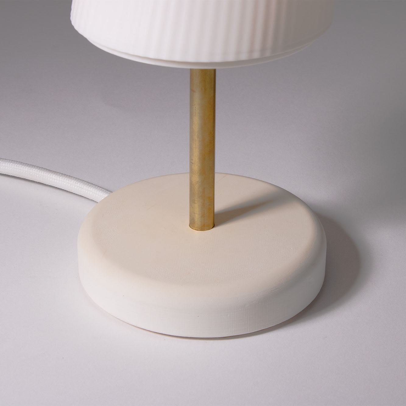 White base of the Ora Premium table lamp photographed against a white background