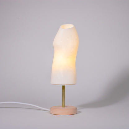 Ora Premium white sculptural table lamp with red plaster base and brass rod photographed against a white background